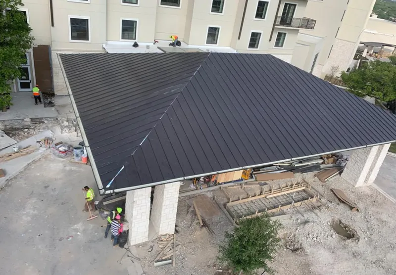 Metal roofing installation team working on a commercial building in Acton
